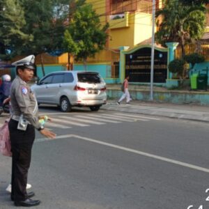 Satlantas Polres Bima Kota Bantu Anak Sekolah Menyeberang Jalan dalam Gatur Pagi